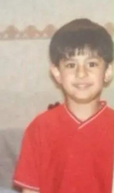 A young Junaid Ahmed smiling at the camera.