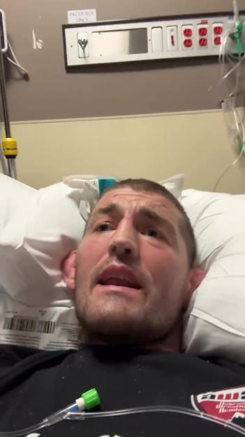 Ben Askren lying in a hospital bed with an IV line attached.