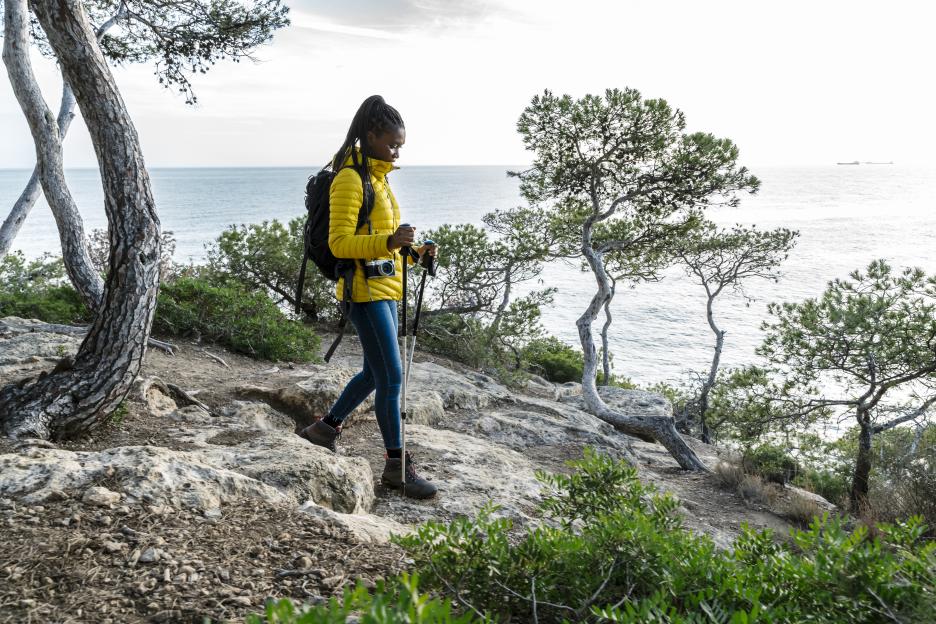 Middle-aged woman hiking in the mountains next to the Mediterranean Sea.