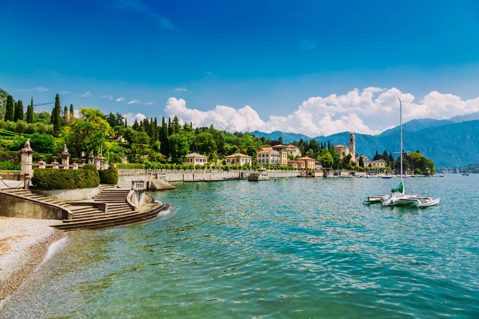 Shore of Lake Como in Tremezzo, Italy, with villas and mountains in the background.