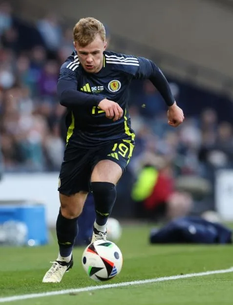 A Scotland football player dribbles the ball during an international friendly match against Finland.