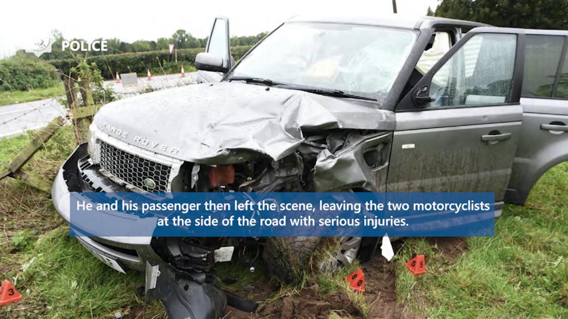 A Range Rover with significant front-end damage and open doors, off the road in grass and mud.