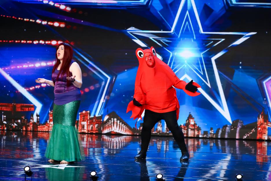 Katherine O'Malley as Ariel singing, with Joe O'Malley as a red crab on stage.