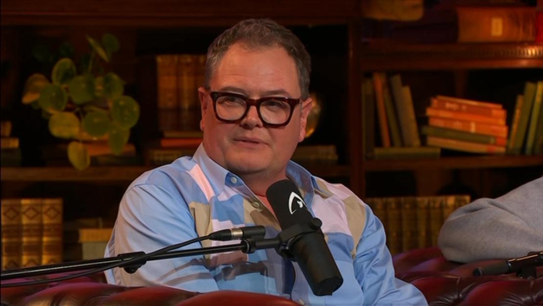 Alan Carr speaking into a microphone.
