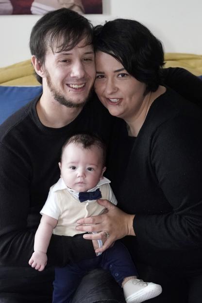 Alaina Goode and Peter, parents of baby Robin, smiling at the camera.