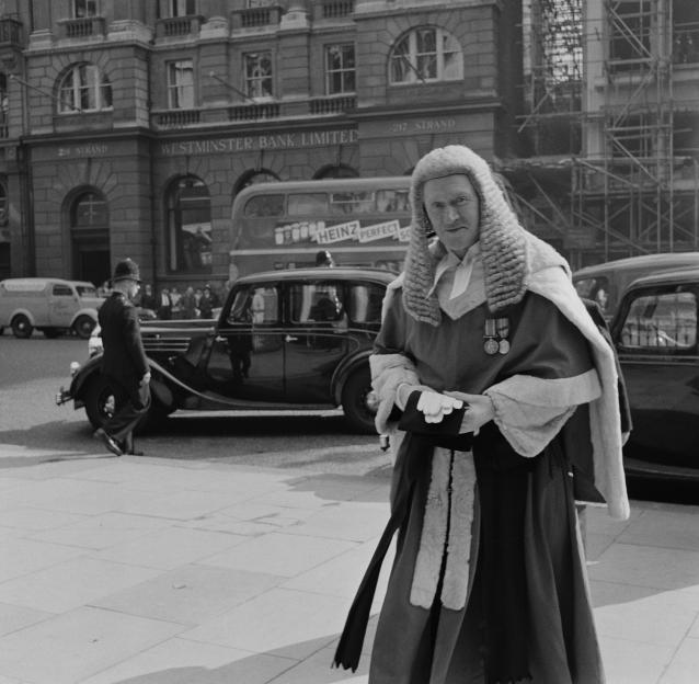 Judge Cecil Havers in full judicial robes and wig, outside the Royal Courts of Justice.