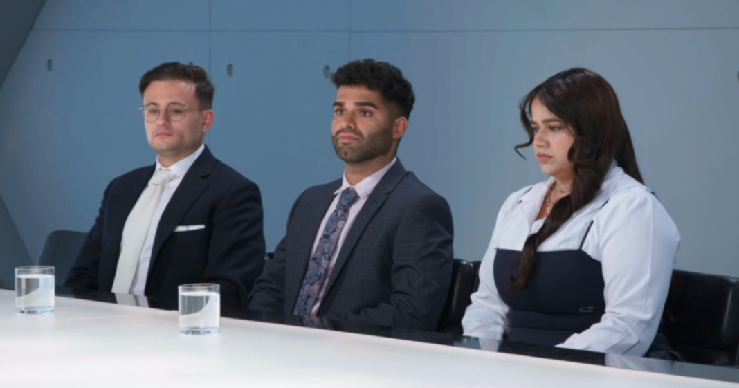 Three solemn people, two men and one woman, sit at a white table with water glasses.
