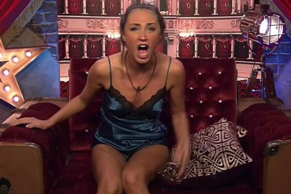 Megan McKenna screaming on a red velvet chair.