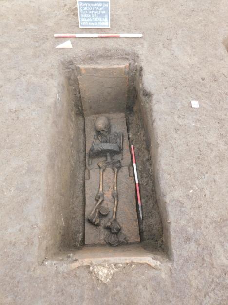 Archaeological burial site of a skeleton of a child wearing a warrior belt.