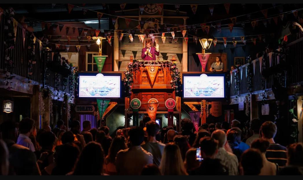 Immersive experience at Phantom Peak, with a speaker on a stage and a crowd watching.