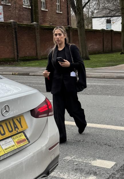 Sana Aslim, a beautician, walking past a white Mercedes car.
