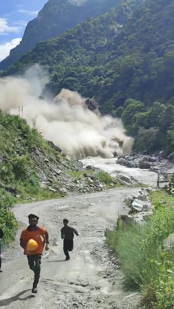 People running from a flash flood in a mountainous region.