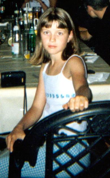 Jessica Chapman, a ten-year-old girl, wearing a white top and sitting at a table with bottles and glasses in the background.
