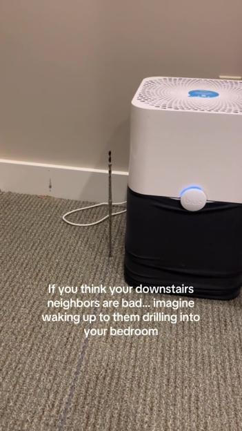 A drill bit protruding from the floor next to an air purifier.