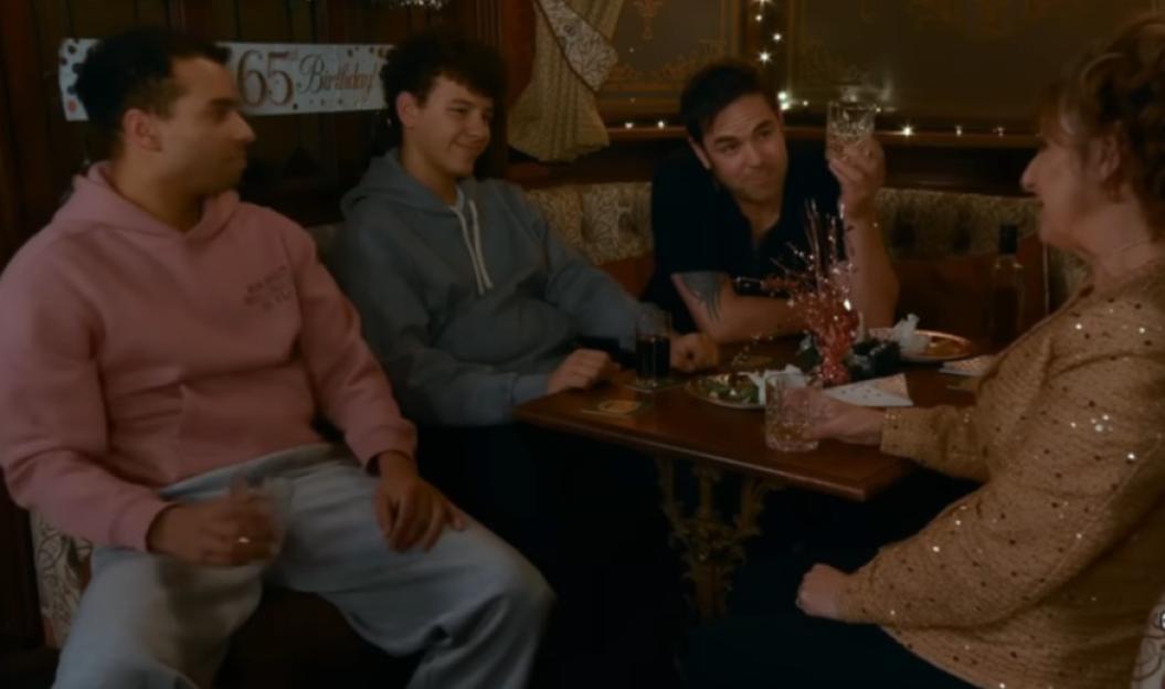 Three men and a woman sitting at a table in a pub.