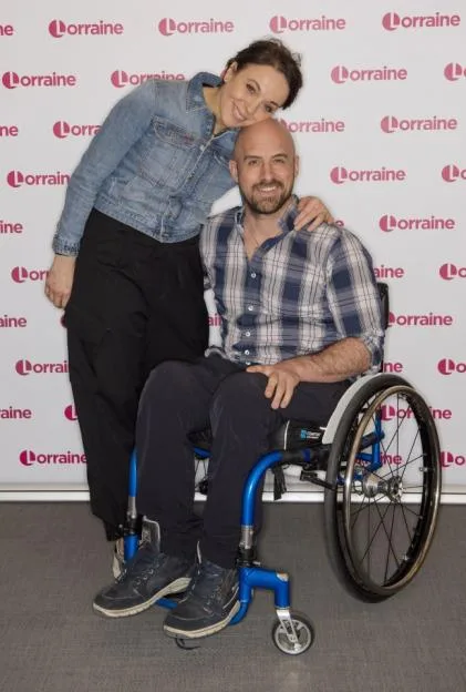 Amanda Abbington and Jonathan Goodwin pose together in front of a "Lorraine" branded backdrop.