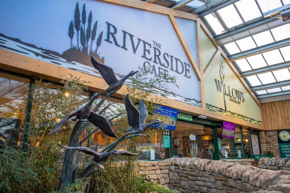A café and restaurant with large signs that read "The Riverside Cafe" and "Willows Restaurant".