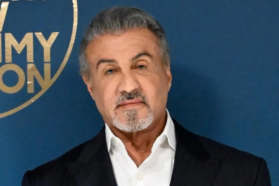 Actor Sylvester Stallone backstage at The Tonight Show, wearing a pinstriped double-breasted suit and white shirt.