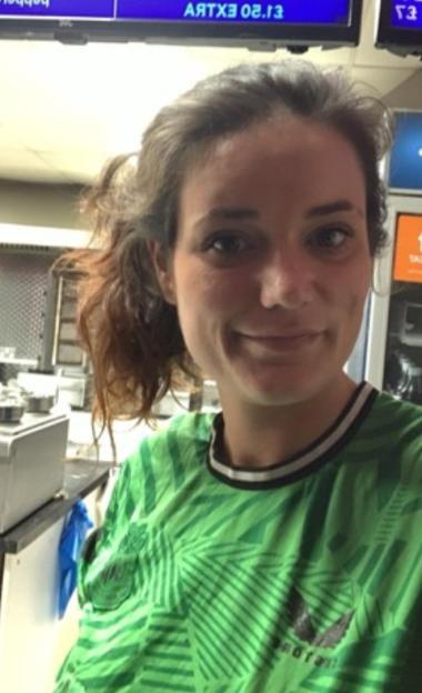 A woman wearing a green shirt with a tropical pattern.