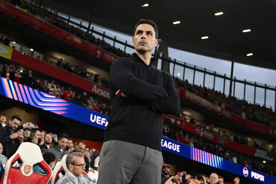 Mikel Arteta stands with arms crossed, observing the UEFA Champions League semi-final match.
