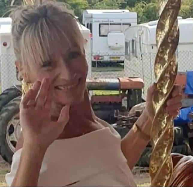 Olive Martin smiling while holding a golden object.