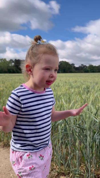 Camilla Thurlow's daughter Nora interacting with crops in a field.