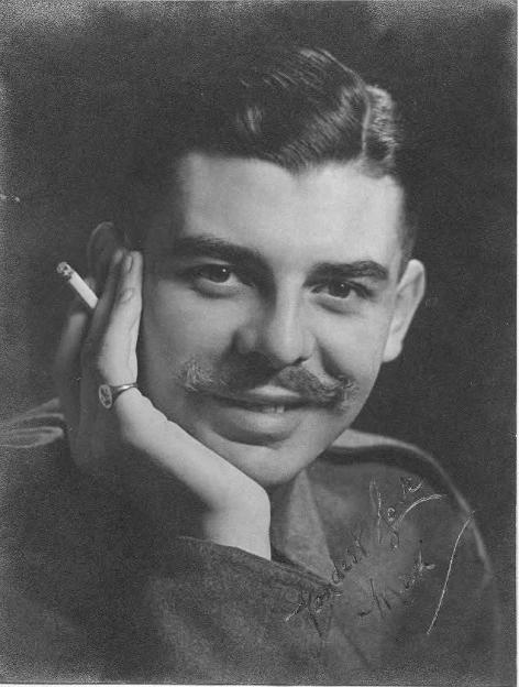 Black and white portrait of William Maxwell Nasmyth Wilcock, a spy, holding a cigarette and wearing a ring with a cross.
