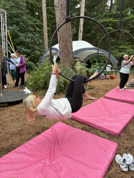 A person hangs upside down from an aerial hoop during Camp Wildfire.