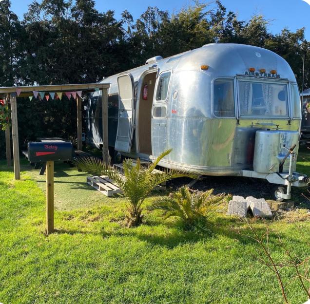 The vintage Airstream caravan "Betsy" at Happy Days Retro Vacations glamping site.