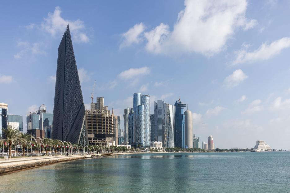 Doha skyline with skyscrapers and waterfront promenade.