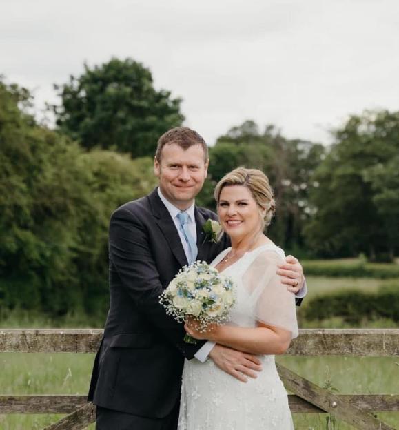 Ashley Peace and her husband pose for a wedding photo.