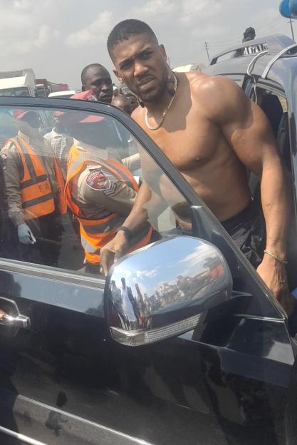 Former heavyweight boxing champion Anthony Joshua looks on as he gets on a vehicle following a car accident near Sagamu.