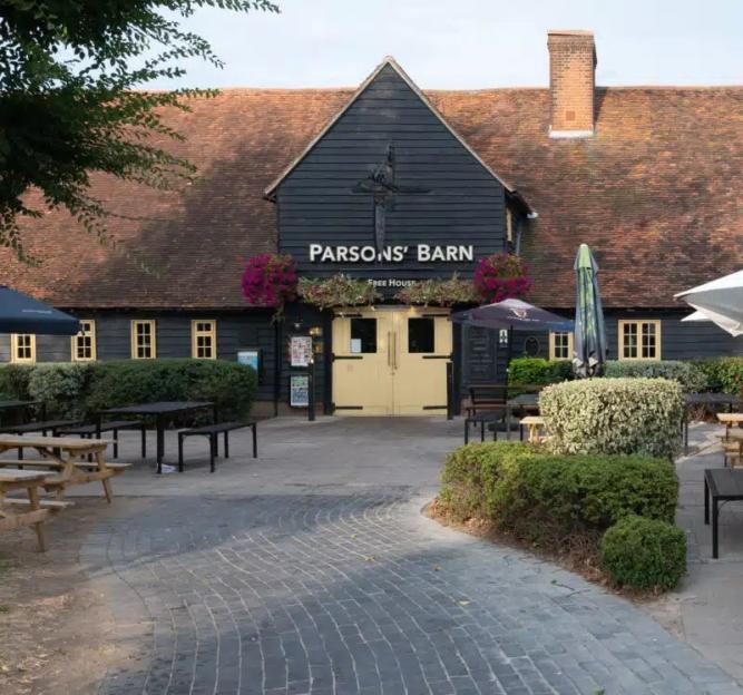 The exterior of Parsons' Barn, a free house, with outdoor seating.