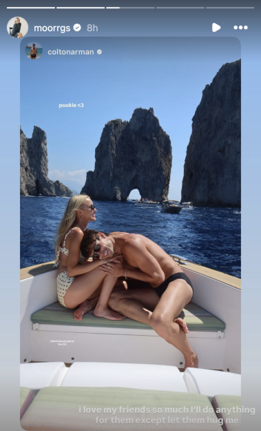 A man resting his head on a woman's lap on a boat, with rock formations and other boats in the background.
