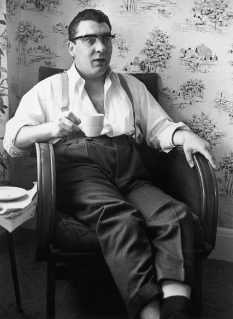 Ronnie Kray sits in a chair, holding a teacup, after 36 hours of police questioning.