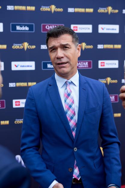 Man in a blue suit and plaid tie at the Concacaf Gold Cup 2023 Official Draw.