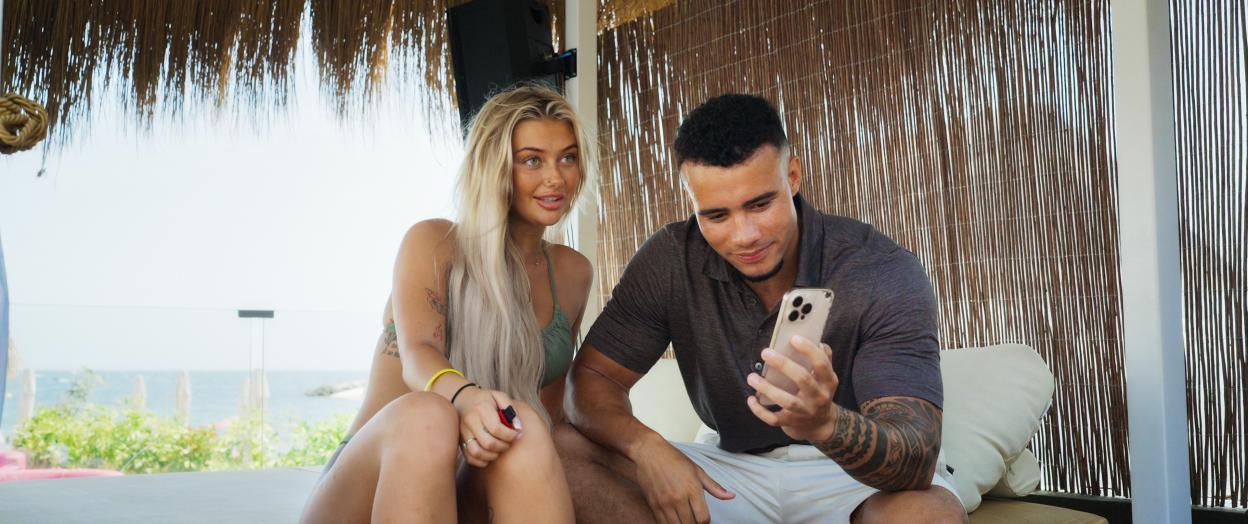 Ellie Nutall looking at Harrison Sullivan (HS Tikky Tokky), who is looking at his phone, in Louis Theroux: Inside the Manosphere.