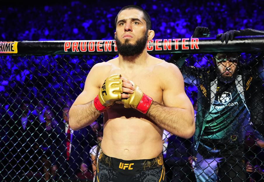 a man in a ufc uniform stands in a cage
