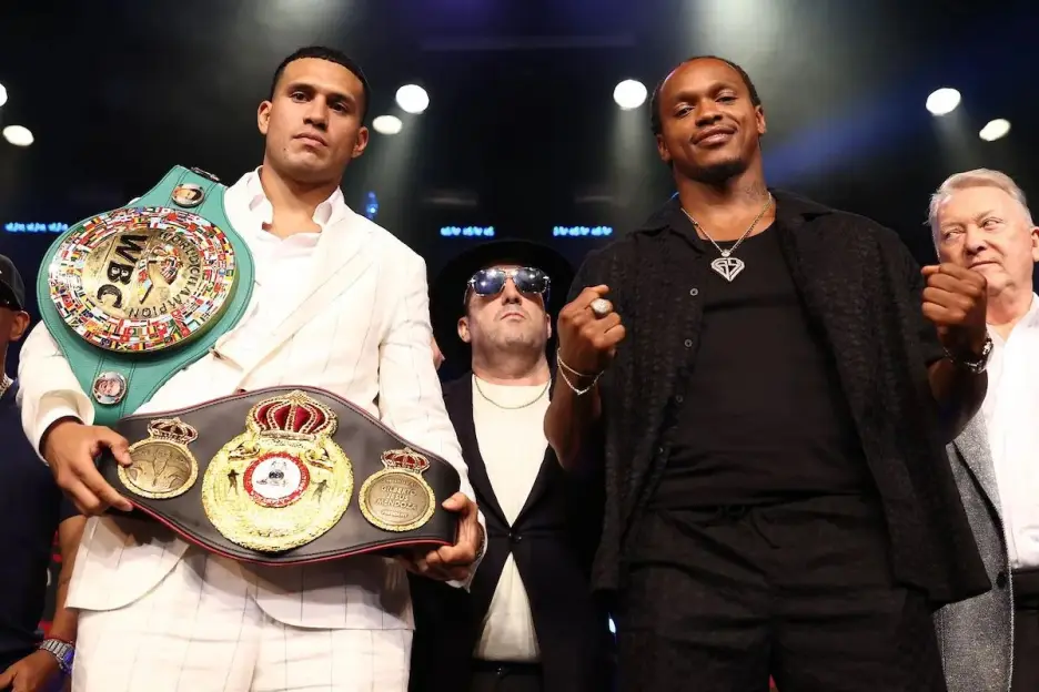 Two male boxers, Benavidez and Yarde, posing with championship belts, accompanied by two other men.