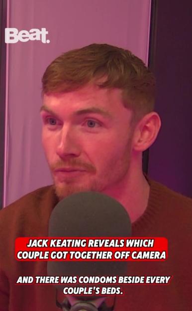 Jack Keating at a microphone, with text overlay "JACK KEATING REVEALS WHICH COUPLE GOT TOGETHER OFF CAMERA AND THERE WAS CONDOMS BESIDE EVERY COUPLE'S BEDS."