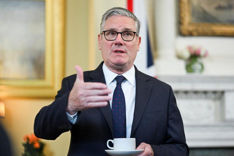 Britain's Prime Minister Keir Starmer speaking at a reception, holding a teacup and gesturing with his other hand.