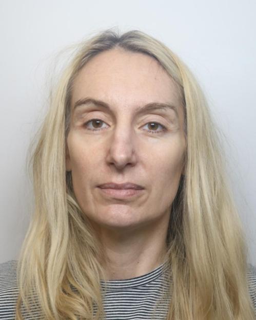 A woman with long blonde hair and a striped top looking directly at the camera.