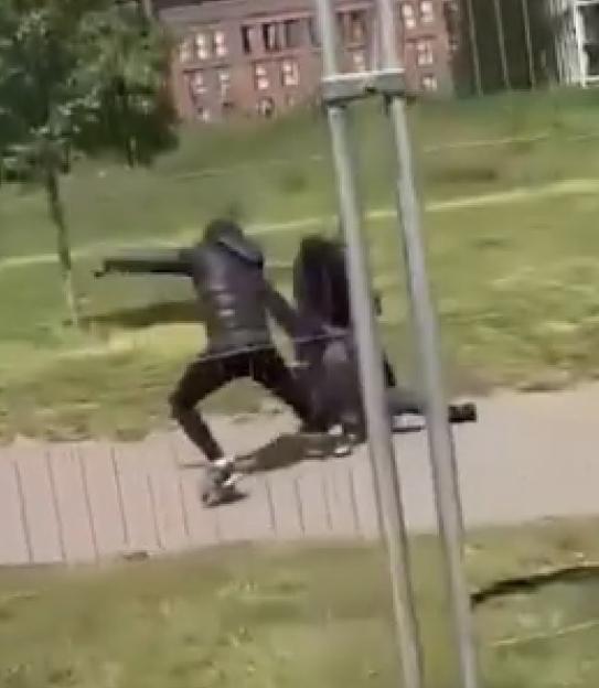 Two people fighting in a park.