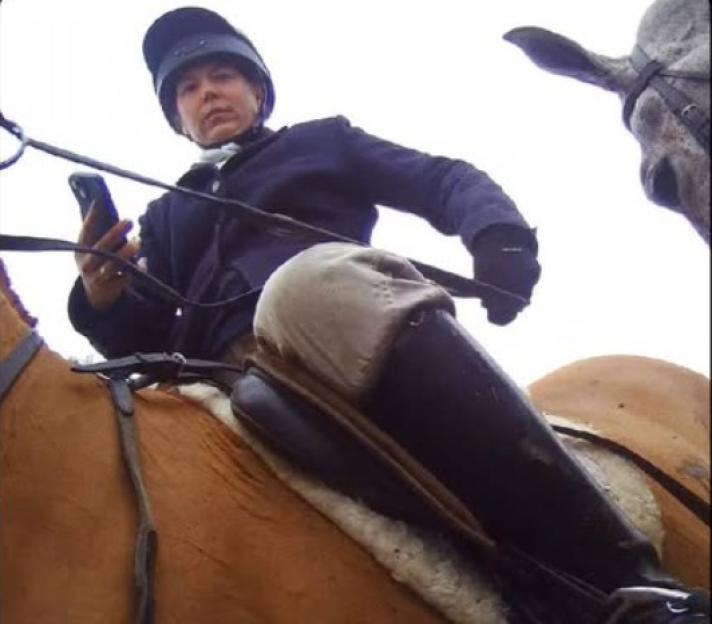 Sophie Tuffin on horseback, holding a phone, at the time of an alleged assault.