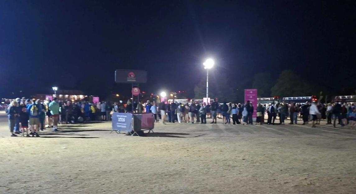 A crowd of people gathered outside at night.
