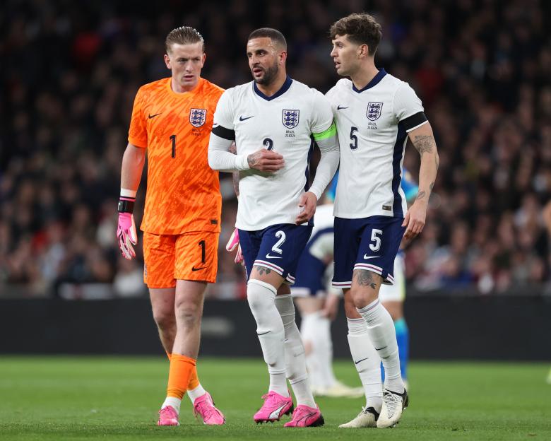 England's Jordan Pickford and John Stones help injured Kyle Walker off the pitch.