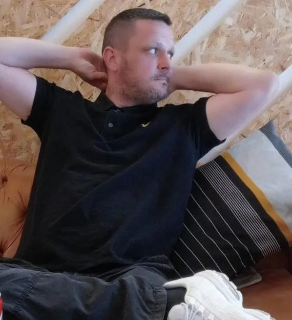 James seated on a sofa with his hands behind his head.