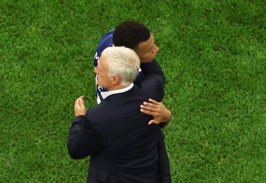 French national team coach Didier Deschamps embraces Kylian Mbappé during a semi-final match against Spain.