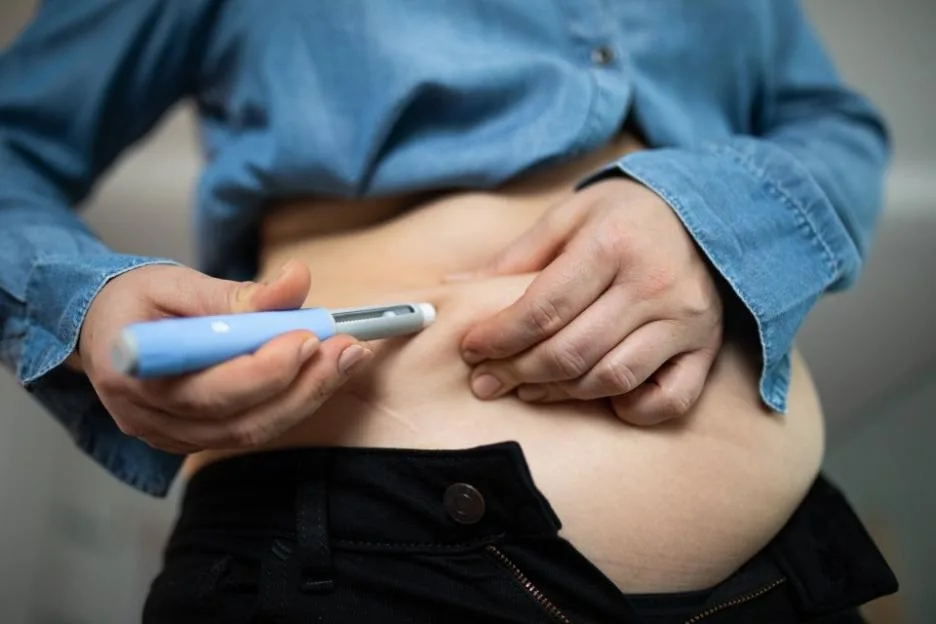 Close-up of a person administering semaglutide injection for weight loss.