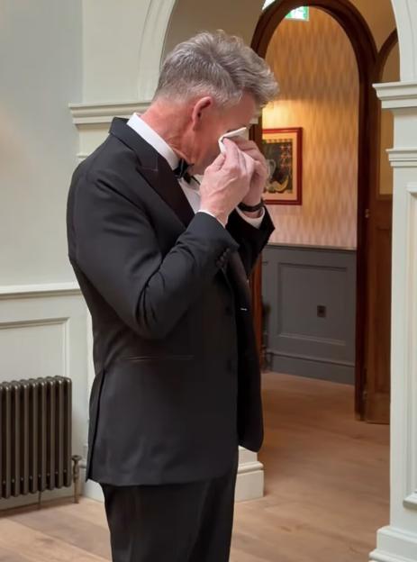 Gordon Ramsay wiping tears from his eyes while wearing a tuxedo.